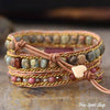 Multistrand beaded bracelet with leather wrap on a textured surface, 'Free Spirit Shop' branding visible.